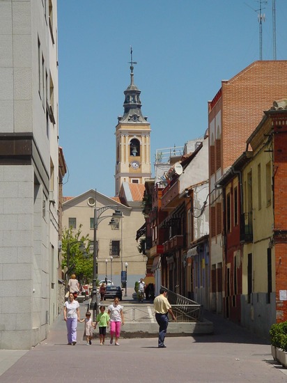 Calle con campanario de iglesia al fondo en Getafe