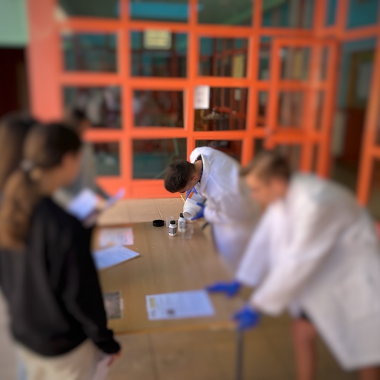 Alumnos de 3º ESO visitan un stand donde alumnos de 4º ESO realizan un experimento