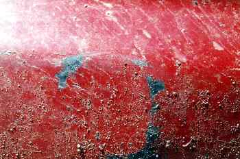 Chapa de color rojo con manchas de tierra