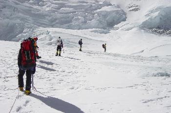Fila de escaladores escalando a lo largo de una cuerda fija