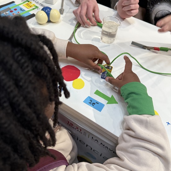 Un niño realiza un experimento de electrolisis en el stand del IES Enrique Tierno Galván de Parla