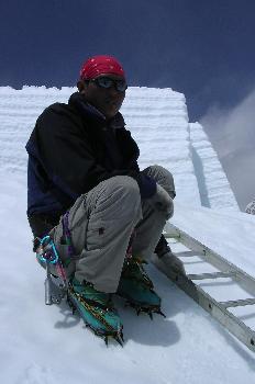 Escalador llevando botas con crampones y jumar con mosquetón