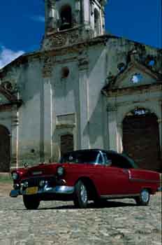 Coche rojo aparcado junto a una iglesia