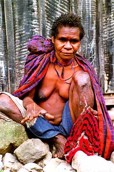 Mujer tejiendo tradicional bolsa de transporte, Irian Jaya, Indo
